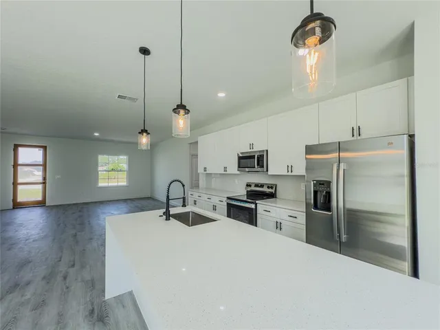 a kitchen with a sink stove and refrigerator