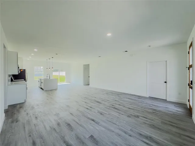 an empty room with a window and wooden floor