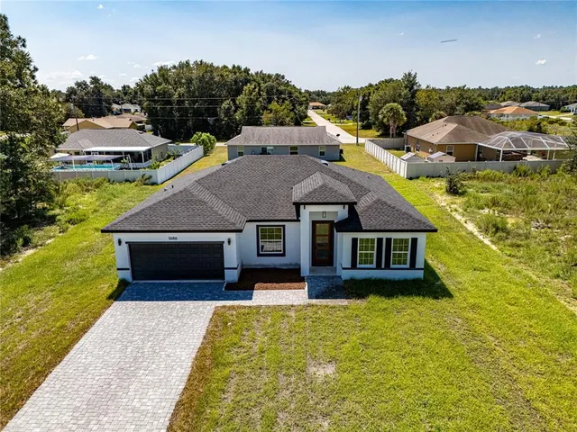 a aerial view of a house with swimming pool next to a yard