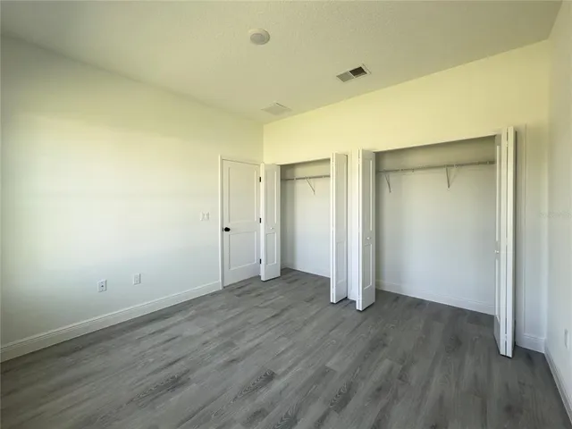 an empty room with wooden floor and closet
