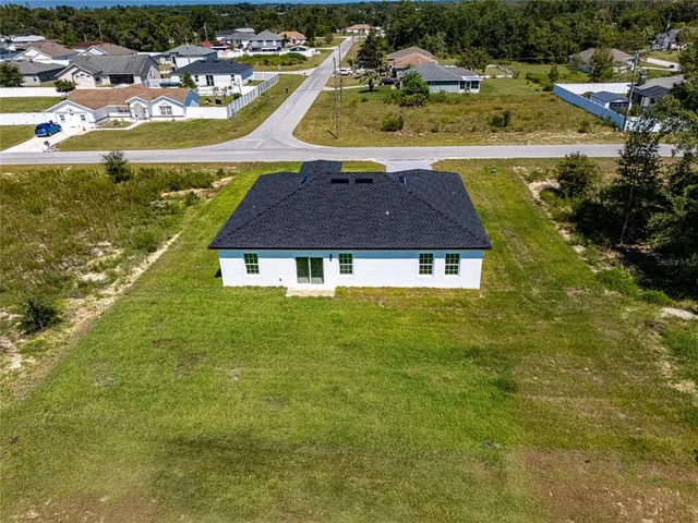 an aerial view of residential houses with outdoor space and swimming pool
