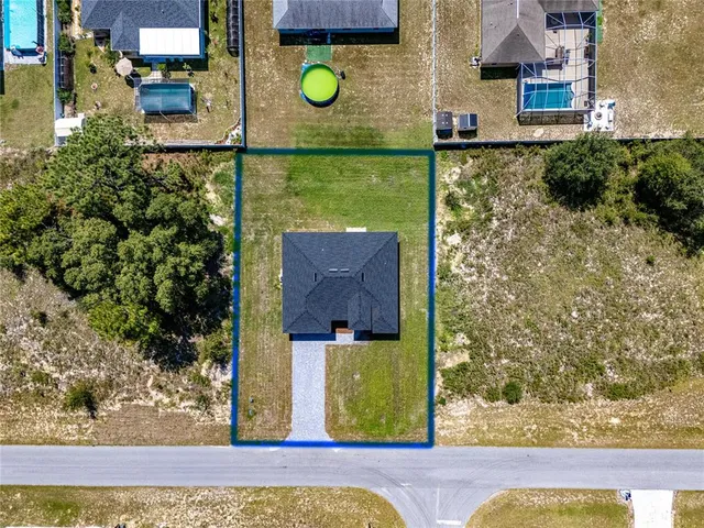 a kitchen with stainless steel appliances granite countertop a sink dishwasher a refrigerator a microwave oven with white cabinets and wooden floor