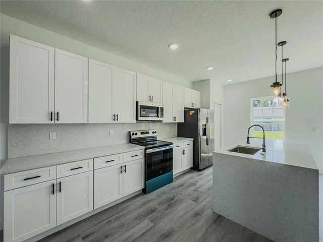 a kitchen with stainless steel appliances a refrigerator and a sink