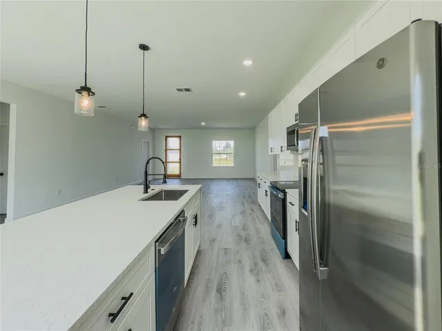 a kitchen with stainless steel appliances a stove microwave and sink