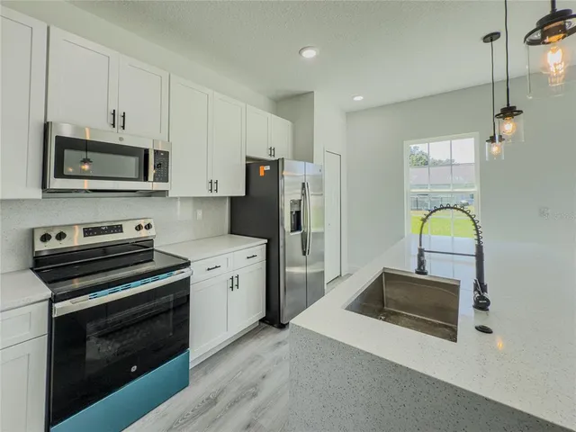 a kitchen with a sink and wooden floor