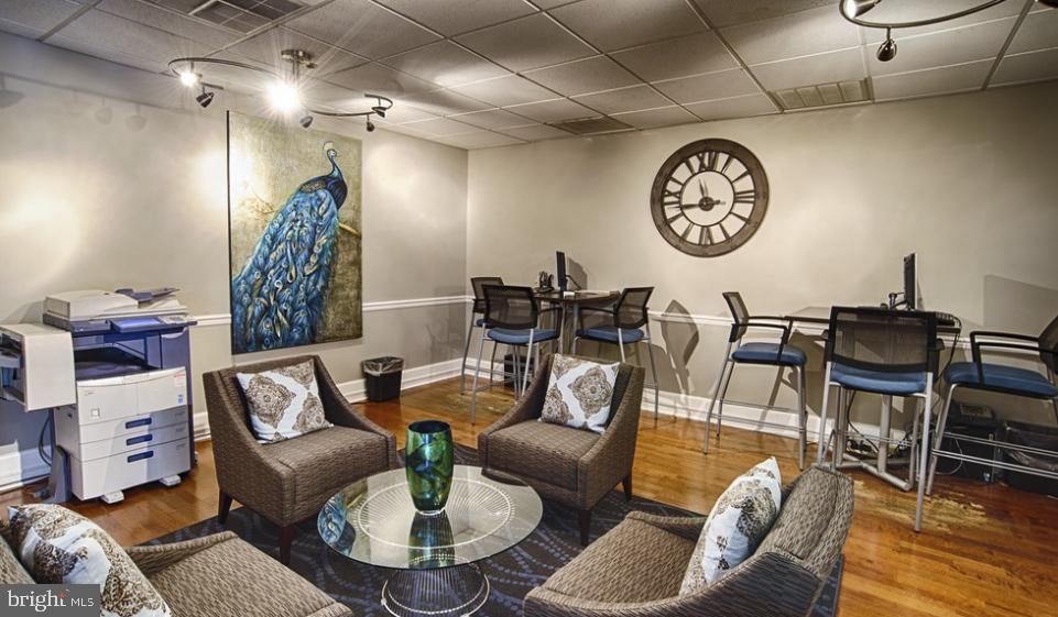 3902 Chestnut Street, Unit 2B1BA Philadelphia, PA 19104 - Photo 16 of 17 a living room with furniture a clock on wall and a table