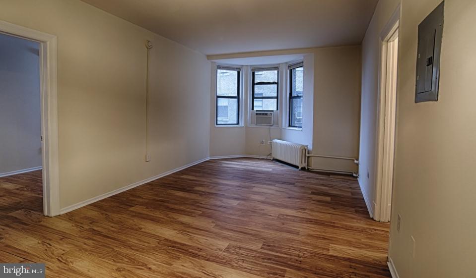 3902 Chestnut Street, Unit 2B1BA Philadelphia, PA 19104 - Photo 5 of 17 an empty room with wooden floor and windows