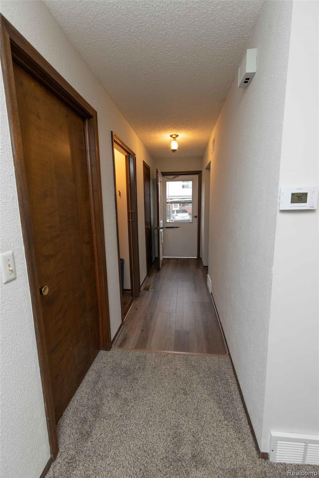 125 Cuttle Road Marysville, MI 48040 - Photo 3 of 44 Hallway with wood-finish flooring, light-toned carpeting, and a ceiling-mounted light fixture