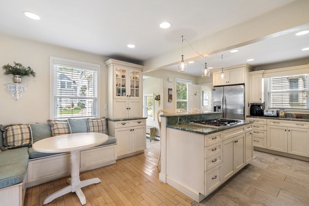 225 Nantasket Road Hull, MA 02045 - Photo 8 of 40 a kitchen with stainless steel appliances granite countertop a stove a sink dishwasher a dining table and chairs with wooden floor