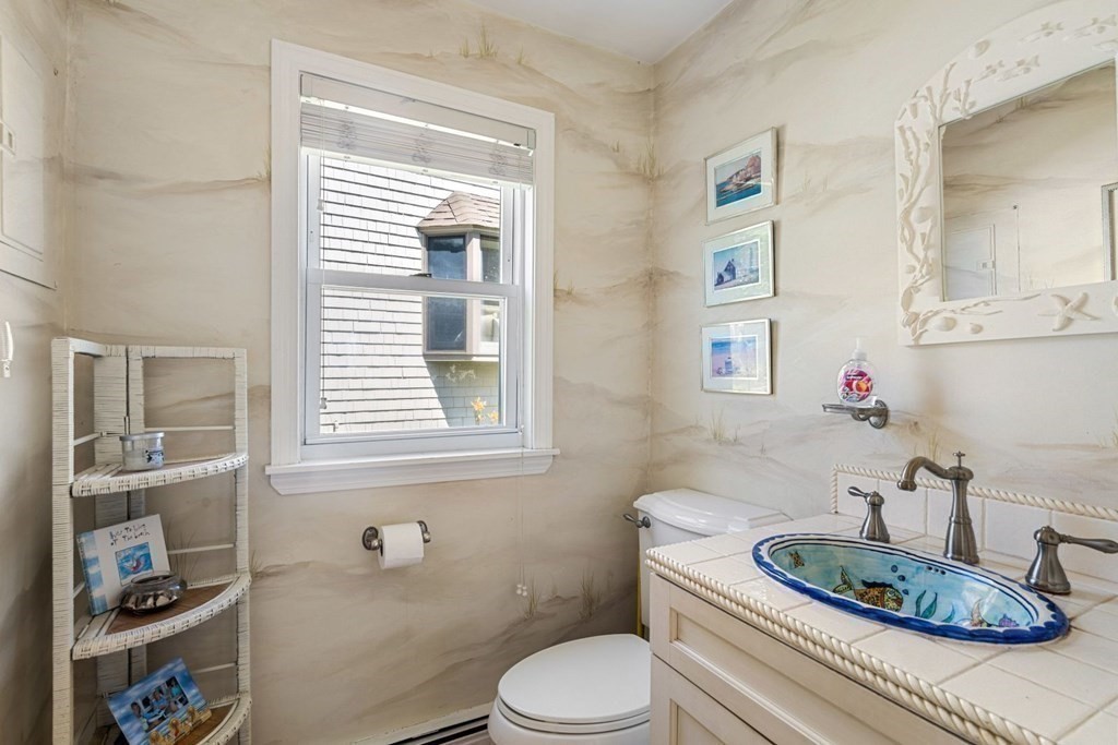 225 Nantasket Road Hull, MA 02045 - Photo 9 of 40 a bathroom with a toilet a sink and a mirror