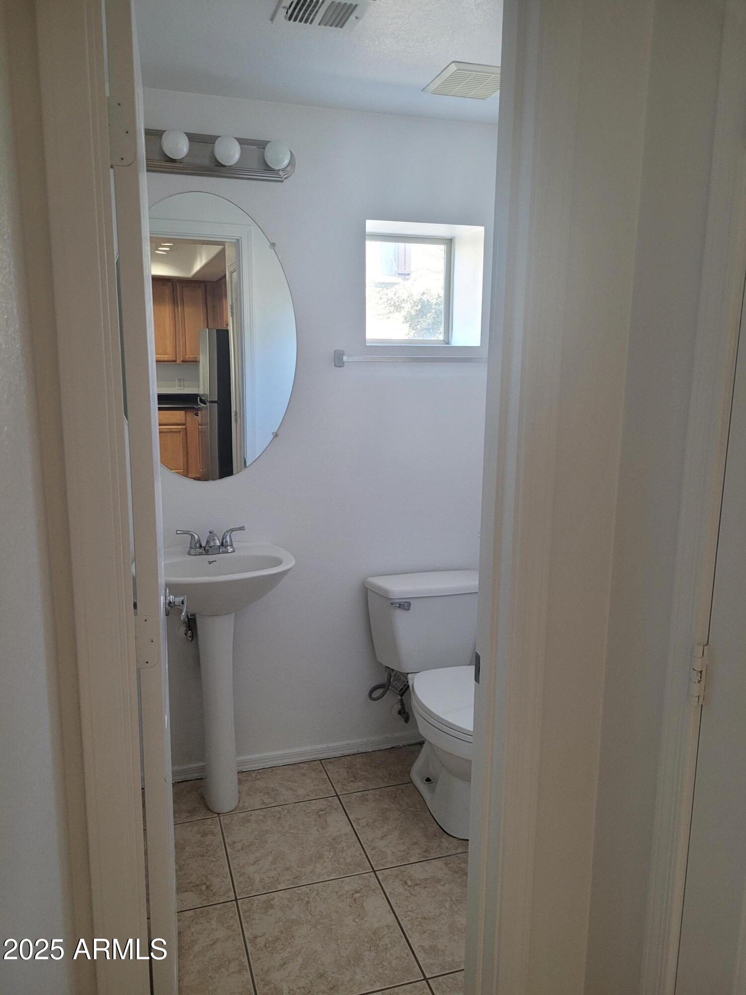 280 South Evergreen Road, Unit 1312 Tempe, AZ 85288 - Photo 11 of 25 a bathroom with a toilet sink and mirror