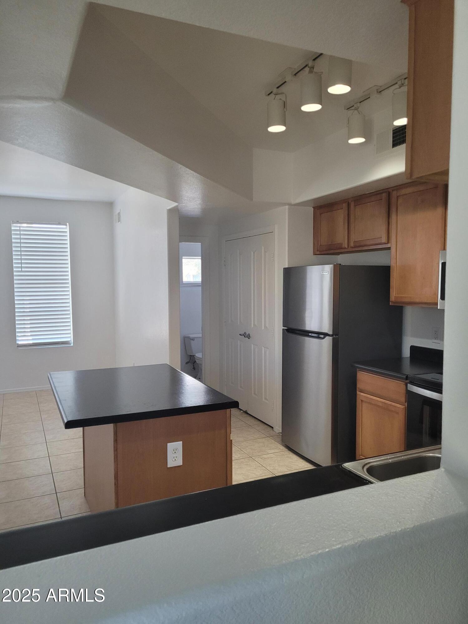 280 South Evergreen Road, Unit 1312 Tempe, AZ 85288 - Photo 3 of 25 a kitchen with stainless steel appliances granite countertop a refrigerator a sink a stove and a refrigerator with wooden floor