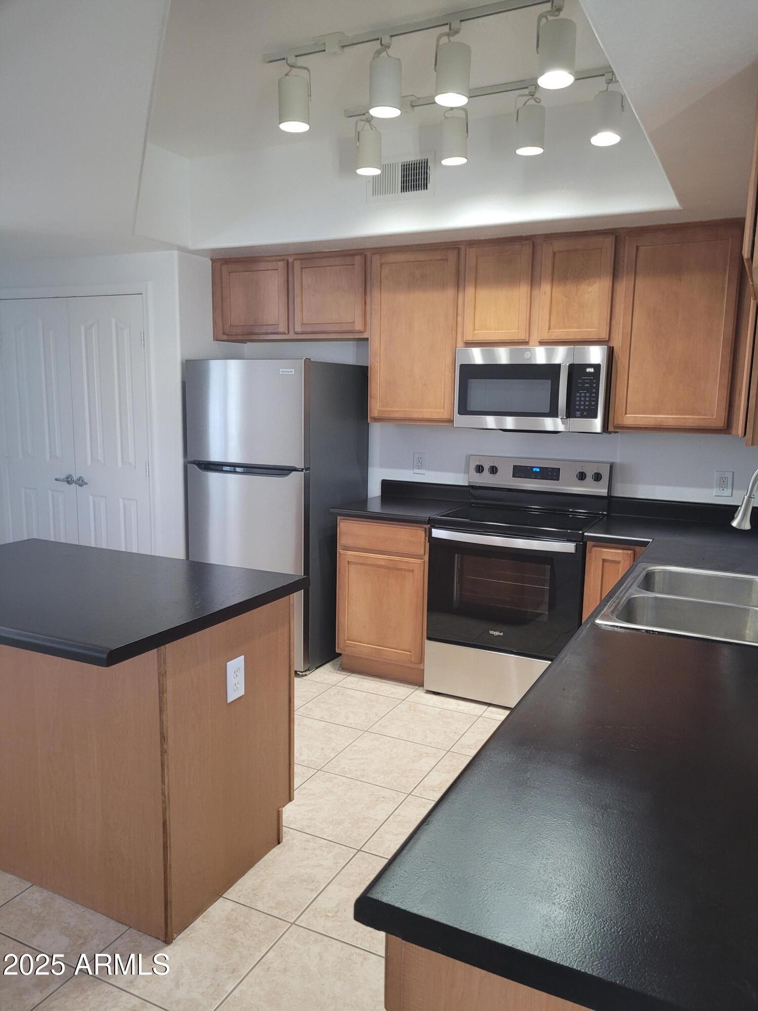 280 South Evergreen Road, Unit 1312 Tempe, AZ 85288 - Photo 4 of 25 a kitchen with stainless steel appliances a refrigerator a sink a stove and a refrigerator