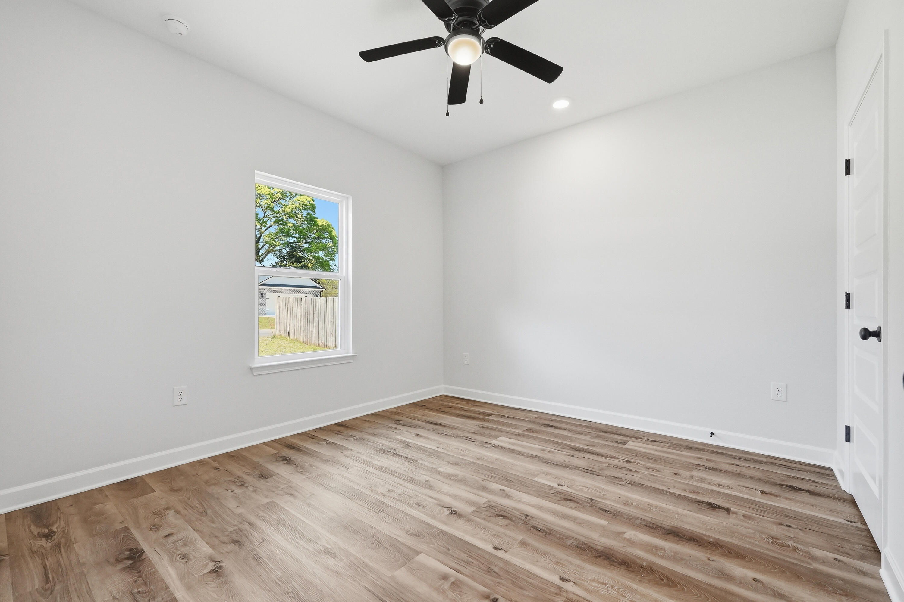 2801 Blackbird Court Crestview, FL 32539 - Photo 18 of 26 an empty room with wooden floor and windows