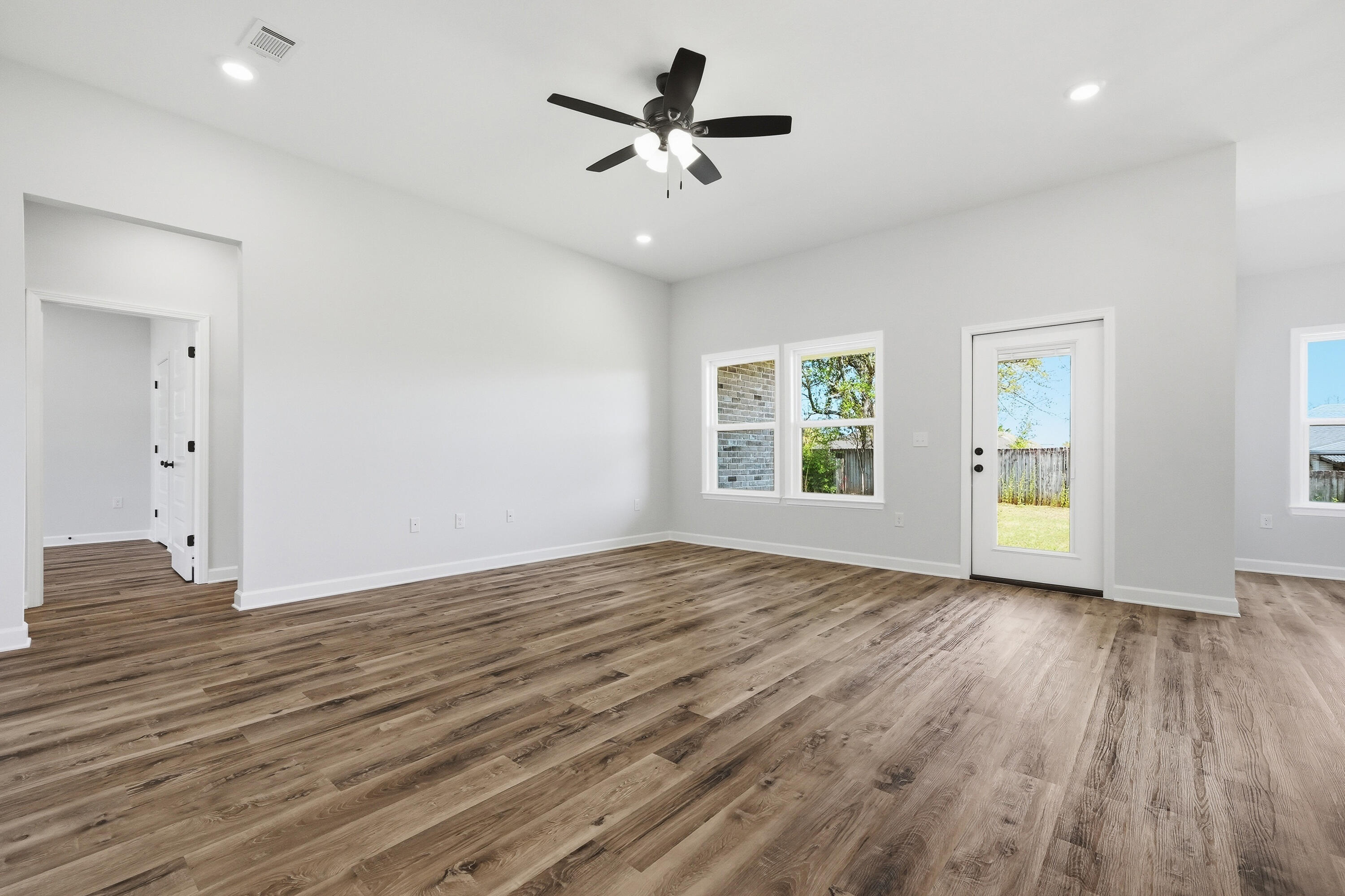 2801 Blackbird Court Crestview, FL 32539 - Photo 5 of 26 an empty room with wooden floor chandelier fan and windows