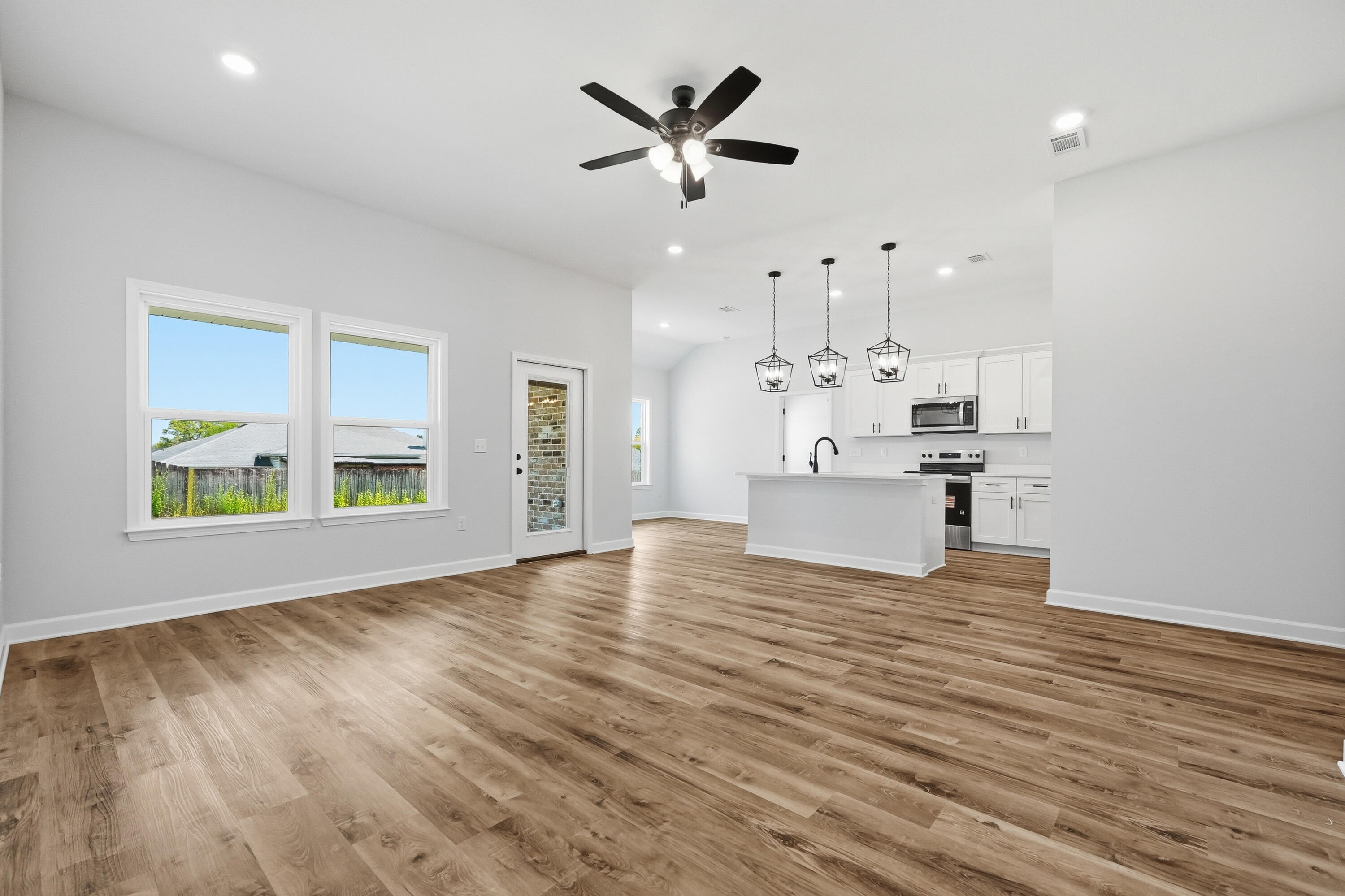 2801 Blackbird Court Crestview, FL 32539 - Photo 6 of 26 a view of empty room with wooden floor and kitchen view