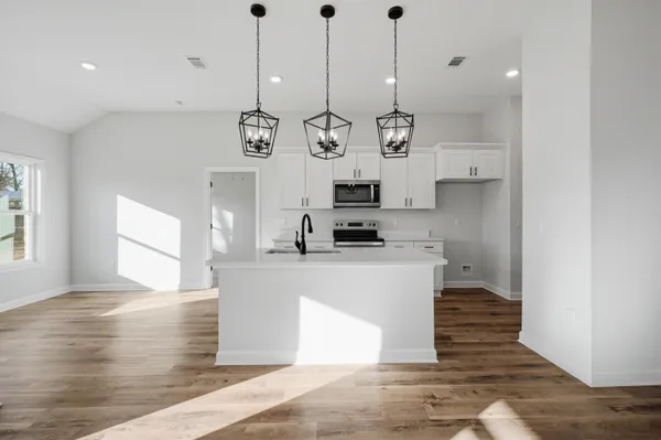 a kitchen with kitchen island a counter top space appliances and cabinets