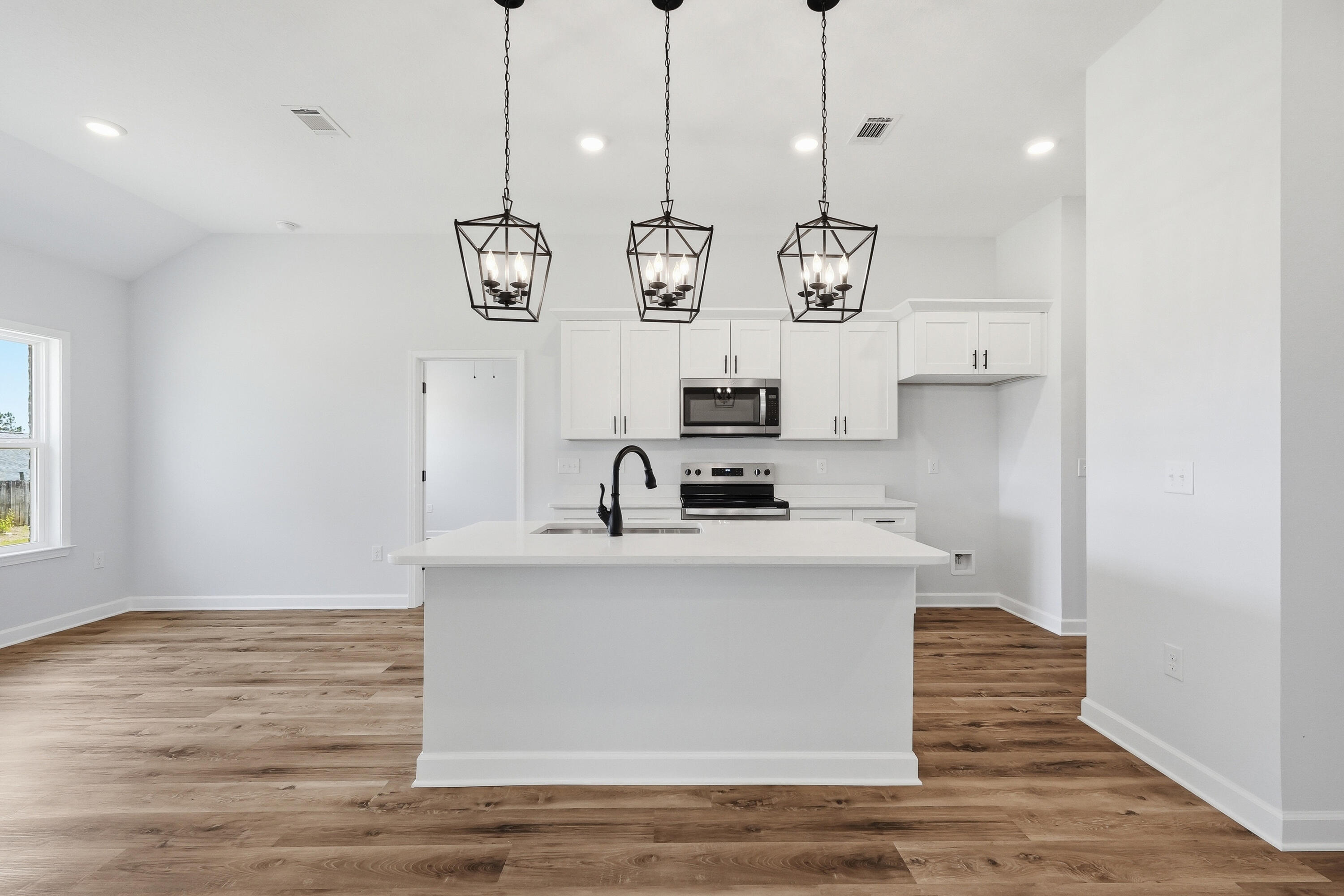 2801 Blackbird Court Crestview, FL 32539 - Photo 9 of 26 a view of a kitchen with stainless steel appliances granite countertop a sink a stove and a wooden floor