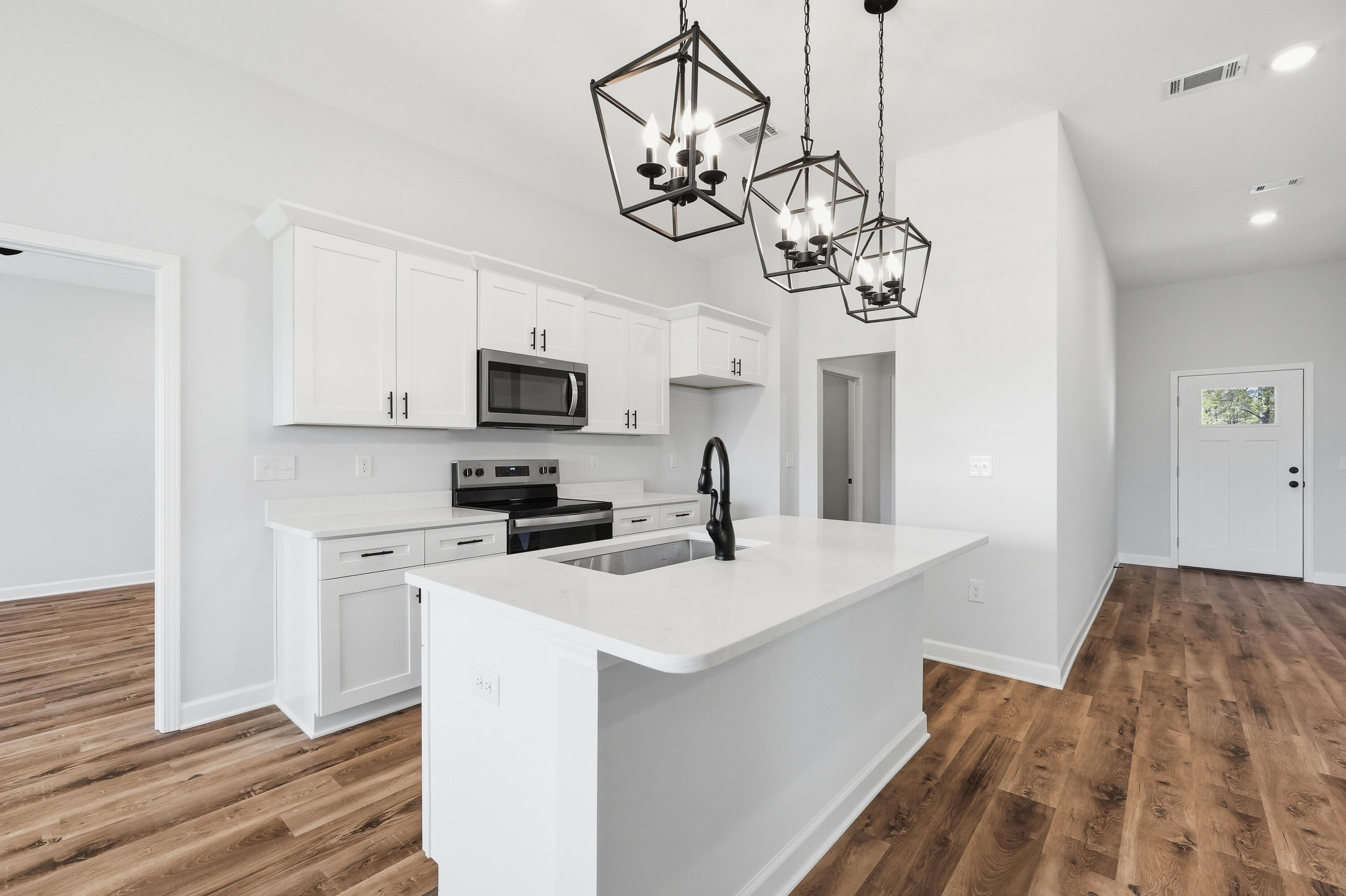 2801 Blackbird Court Crestview, FL 32539 - Photo 10 of 26 a kitchen with stainless steel appliances granite countertop a sink a stove a microwave oven a refrigerator with white cabinets and wooden floor
