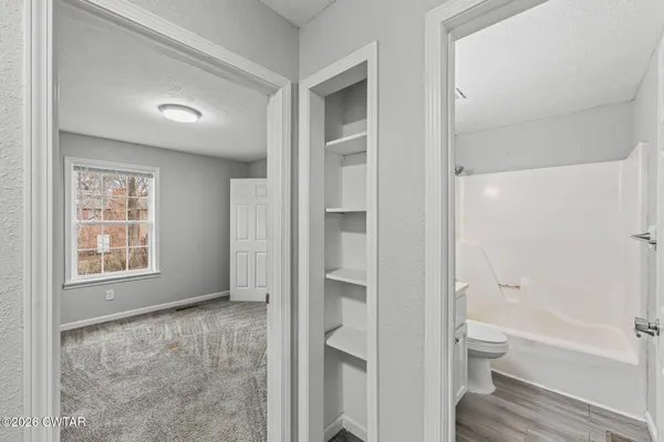 a bathroom with a granite countertop toilet tub and a window