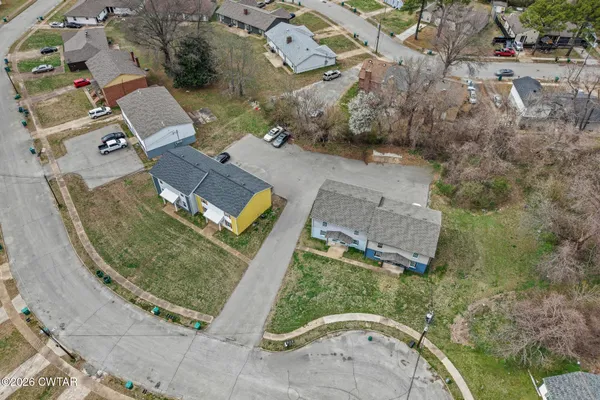 an aerial view of a house with a yard and parking