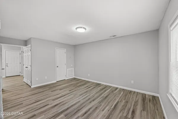 a view of an empty room with wooden floor