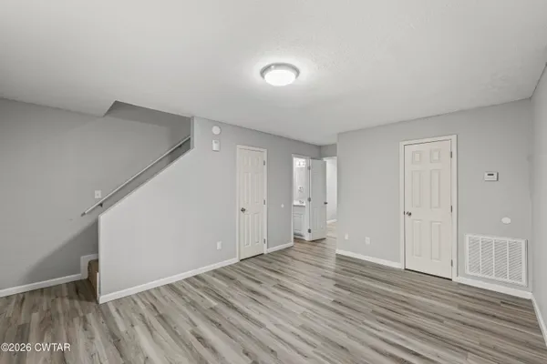 a view of an empty room with wooden floor