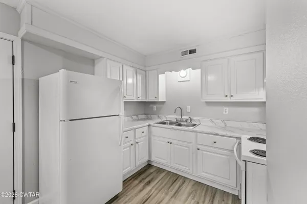 a white refrigerator freezer sitting inside of a kitchen