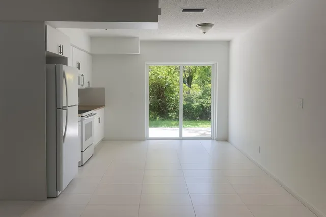 a view of an empty room with a fireplace and a window
