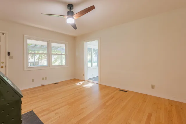 a view of a hallway with wooden floor and closet