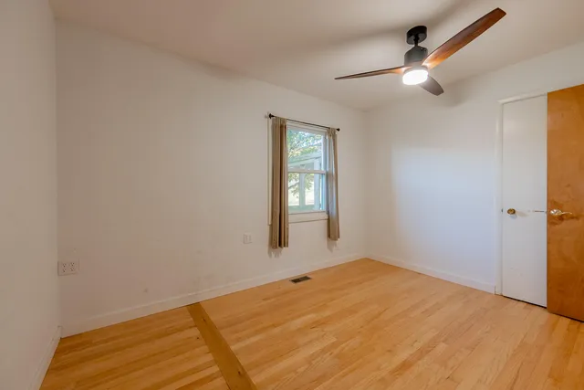 a view of a field with a big yard and a large trees