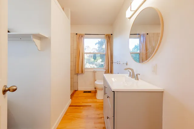 a backyard of a house with plants and large tree