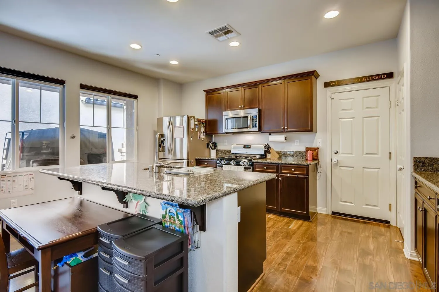 1223 Mason Road Chula Vista, CA 91913 - Photo 7 of 24 a kitchen with kitchen island granite countertop a stove top oven a sink a dining table and chairs