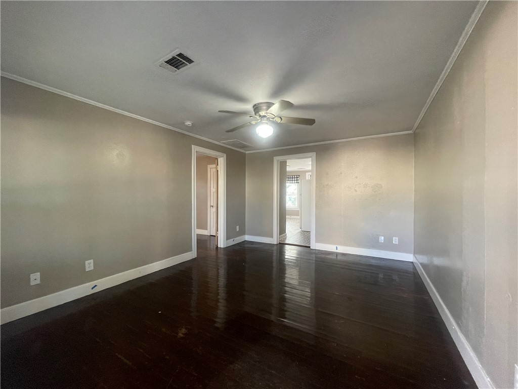 1900 Echols Street, Unit B Bryan, TX 77801 - Photo 3 of 9 an empty room with wooden floor and fan