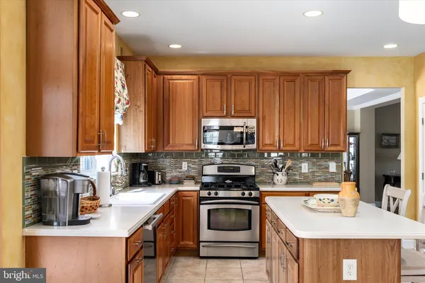 a kitchen with a sink a stove a refrigerator cabinets and dining table