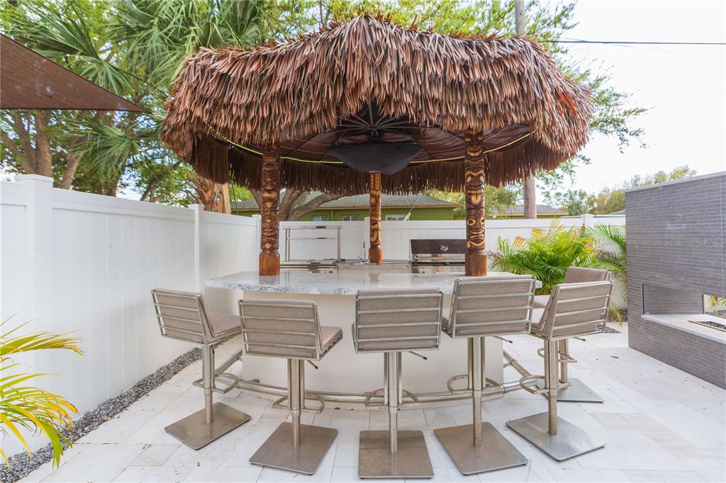 1304 West Arch Street Tampa, FL 33607 - Photo 12 of 75 a view of patio with table and chairs under an umbrella with a barbeque