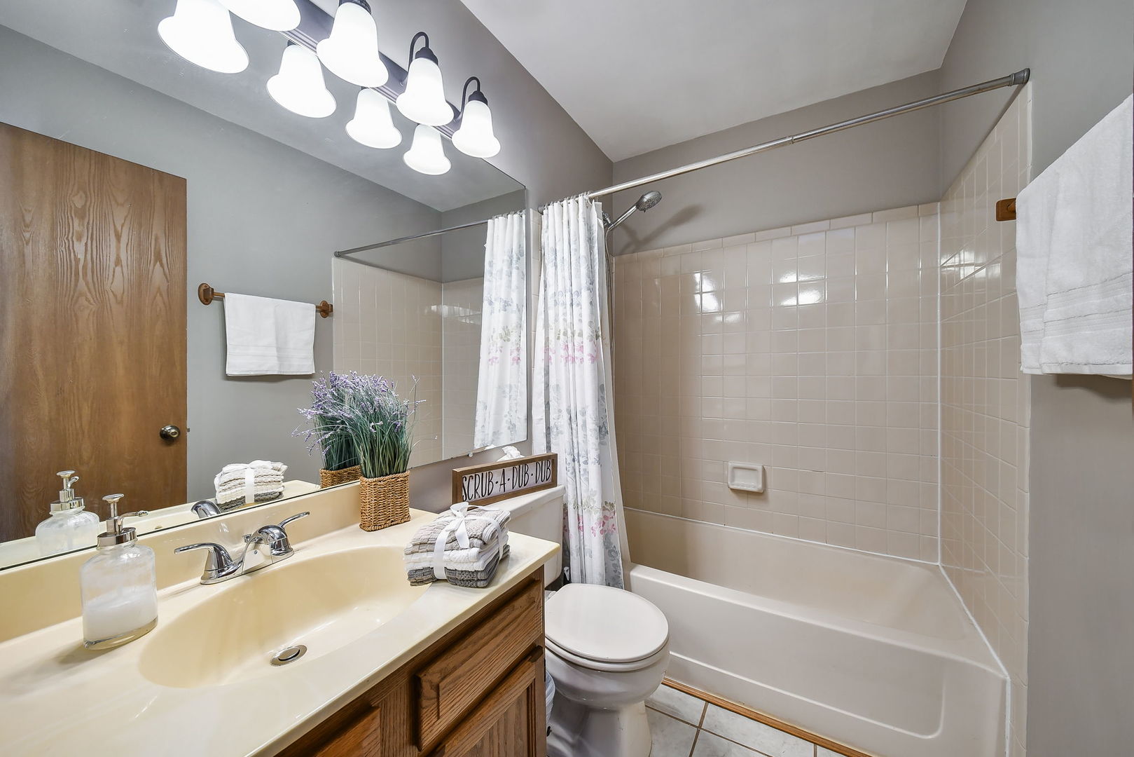 1266 Seabury Circle Carol Stream, IL 60188 - Photo 12 of 22 a bathroom with a sink a toilet a mirror a bathtub and shower