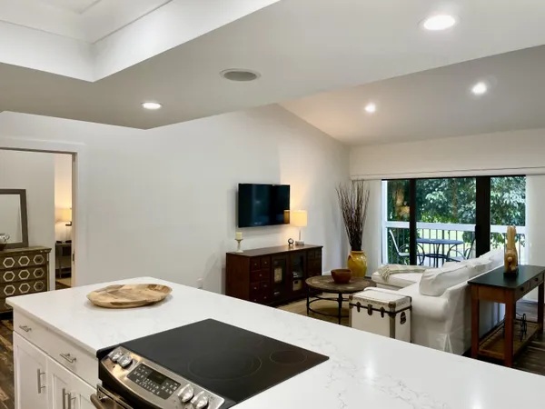 a living room with furniture a flat screen tv and a large window