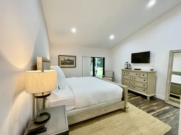 a spacious bedroom with a bed and a flat screen television