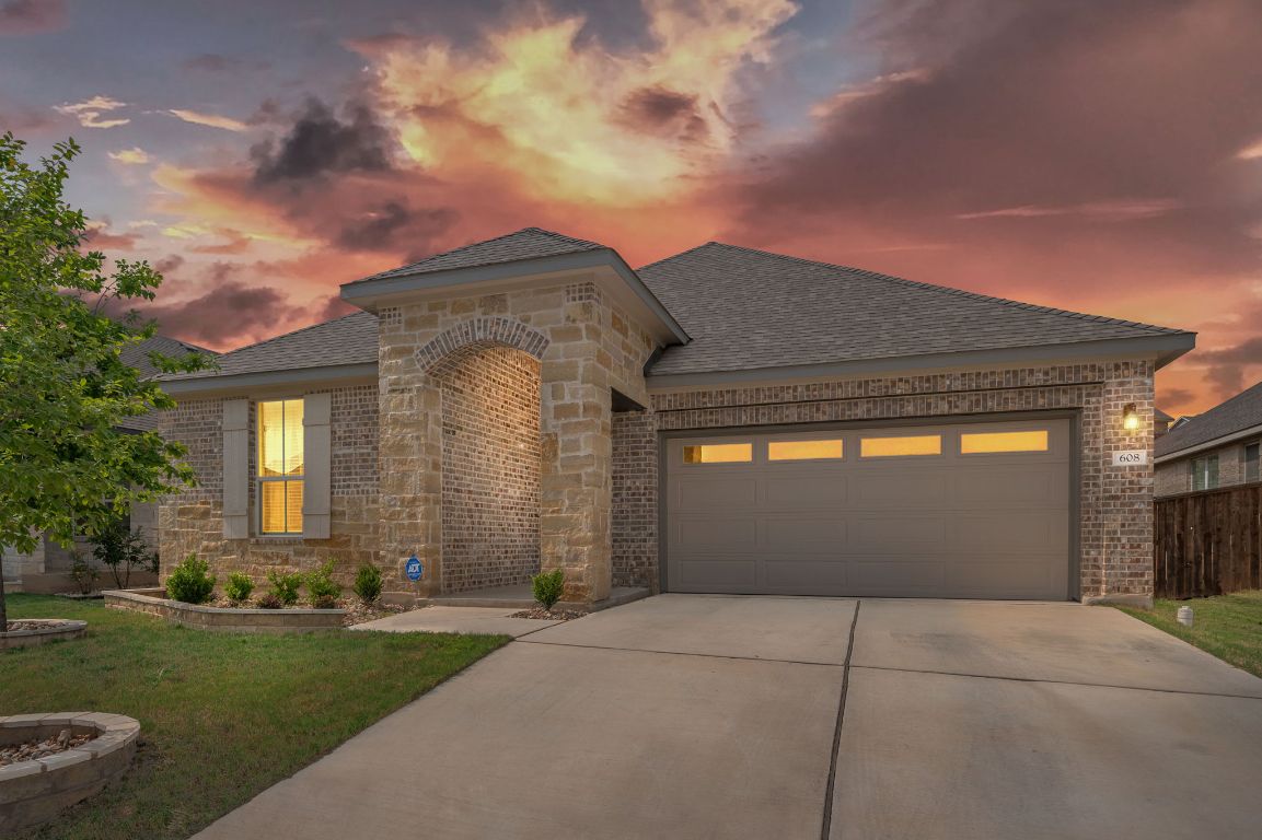 a front view of a house with a garden and yard