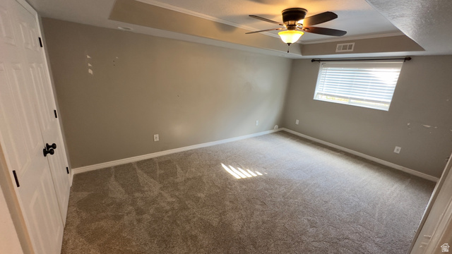 3547 East Golden Eagle Road Eagle Mountain, UT 84005 - Photo 29 of 47 Spare room with a tray ceiling, a ceiling fan, carpet floors, and ornamental molding