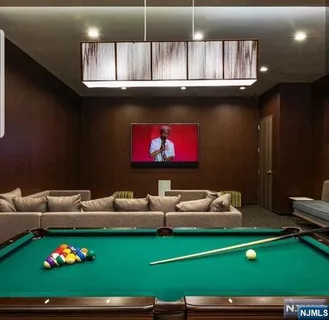 a room with furniture pool table and kitchen view