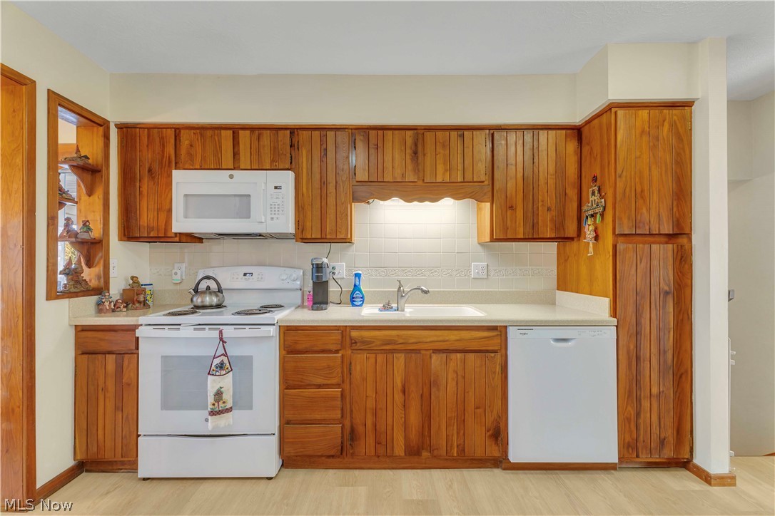 563 North Carpenter Road Brunswick, OH 44212 - Photo 14 of 45 Kitchen with white appliances, light countertops, wood finish cabinetry, and tasteful backsplash