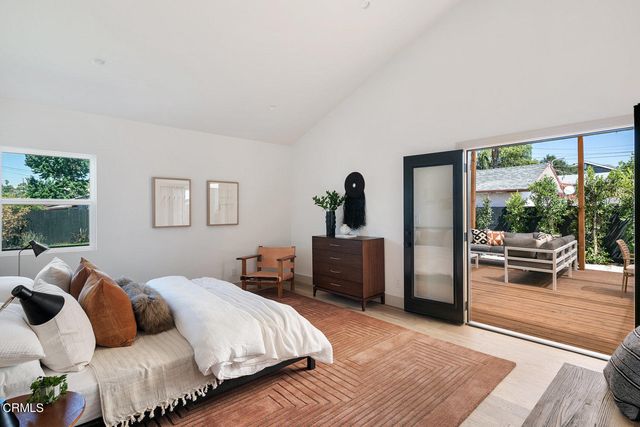 a bedroom with furniture and a large window