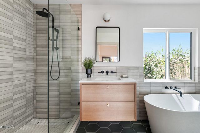a bathroom with a bathtub sink and mirror