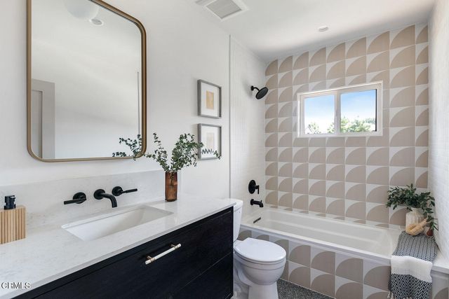 a bathroom with a sink a toilet a tub and shower