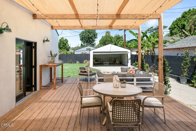 a patio with a table and chairs and potted plants
