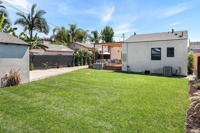 a view of a house with a yard and sitting area