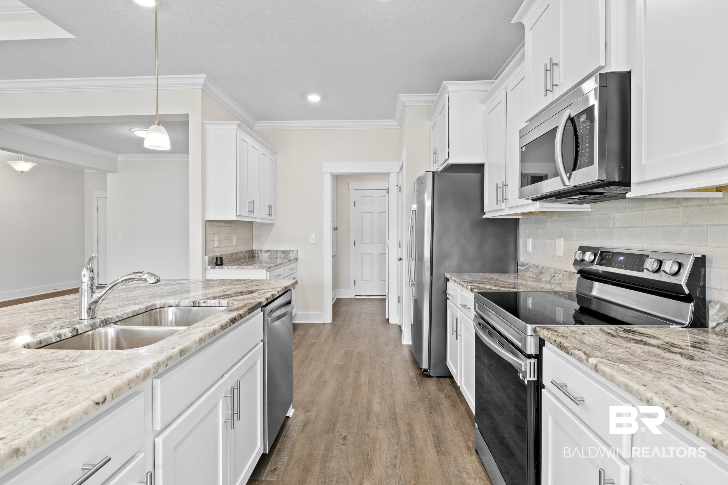 9868 Lakeview Drive Foley, AL 36535 - Photo 19 of 30 Kitchen with crown molding, stainless steel appliances, sink, tasteful backsplash, and light hardwood / wood-style floors