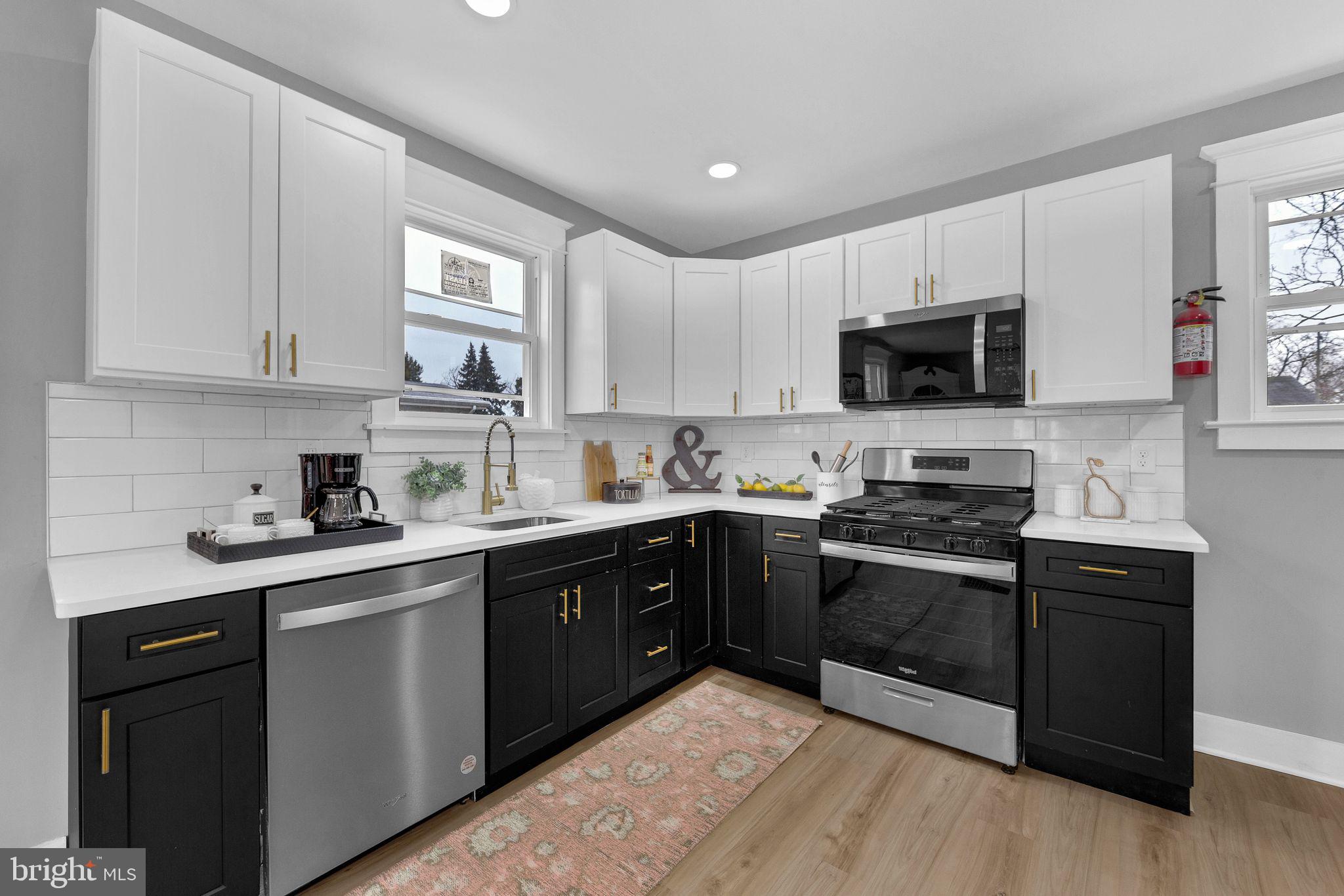 409 Neck Road Burlington, NJ 08016 - Photo 9 of 27 a kitchen with stainless steel appliances granite countertop a sink dishwasher a stove top oven a refrigerator with grey cabinets and wooden floor